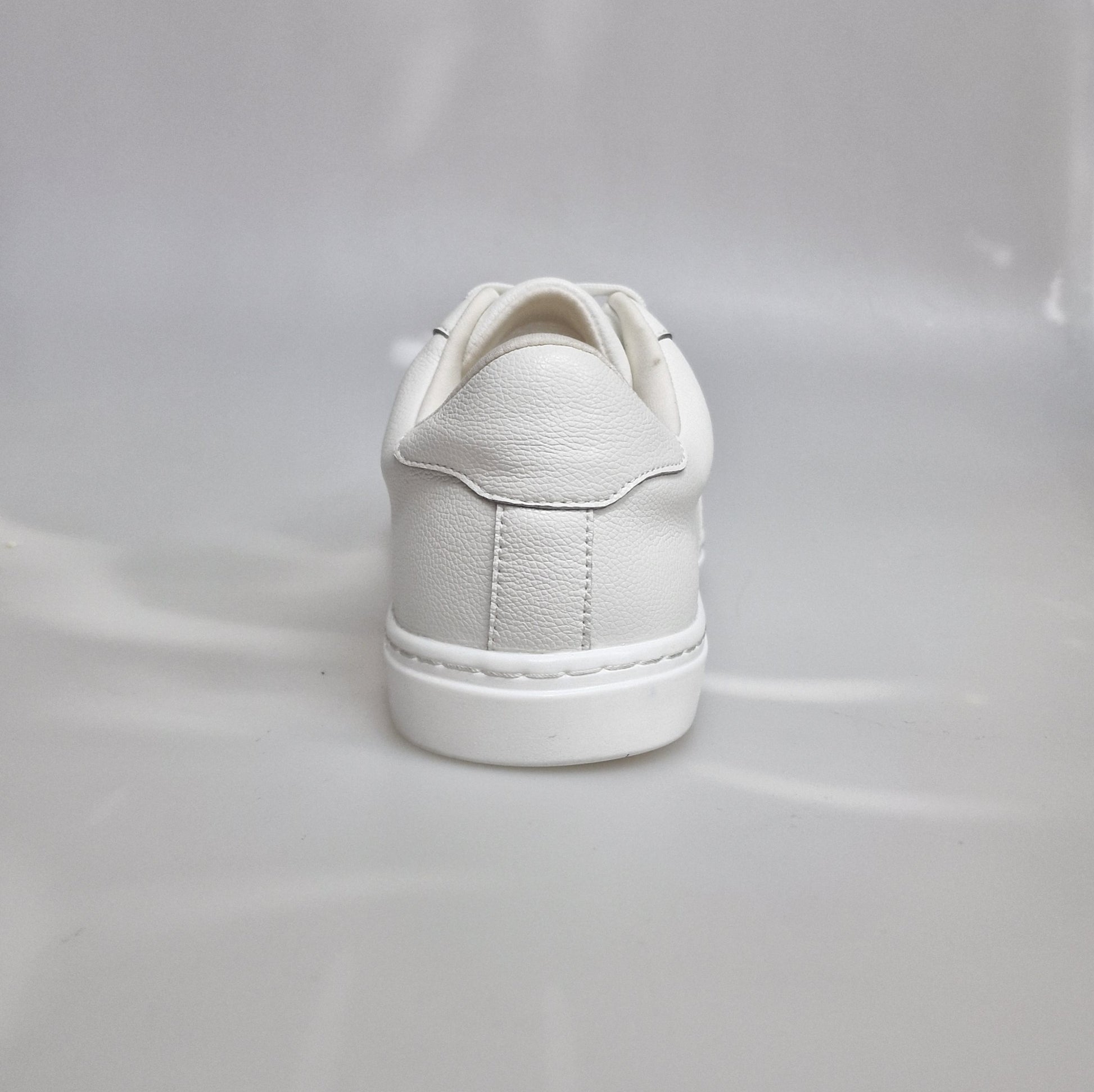 Scarpa sneaker in ecopelle bianca vegan con suola bianca in gomma e resina, dettagli neri e design moderno.