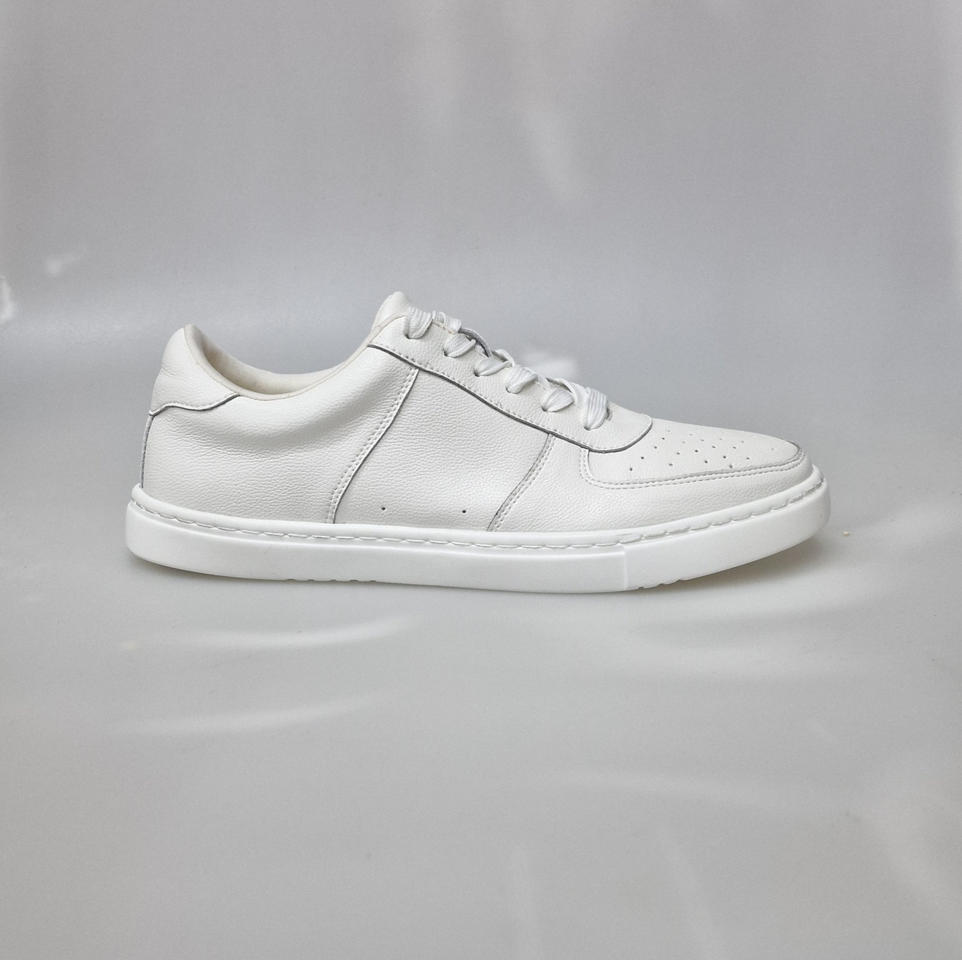 Scarpa sneaker in ecopelle bianca vegan con suola bianca in gomma e resina, dettagli neri e design moderno.