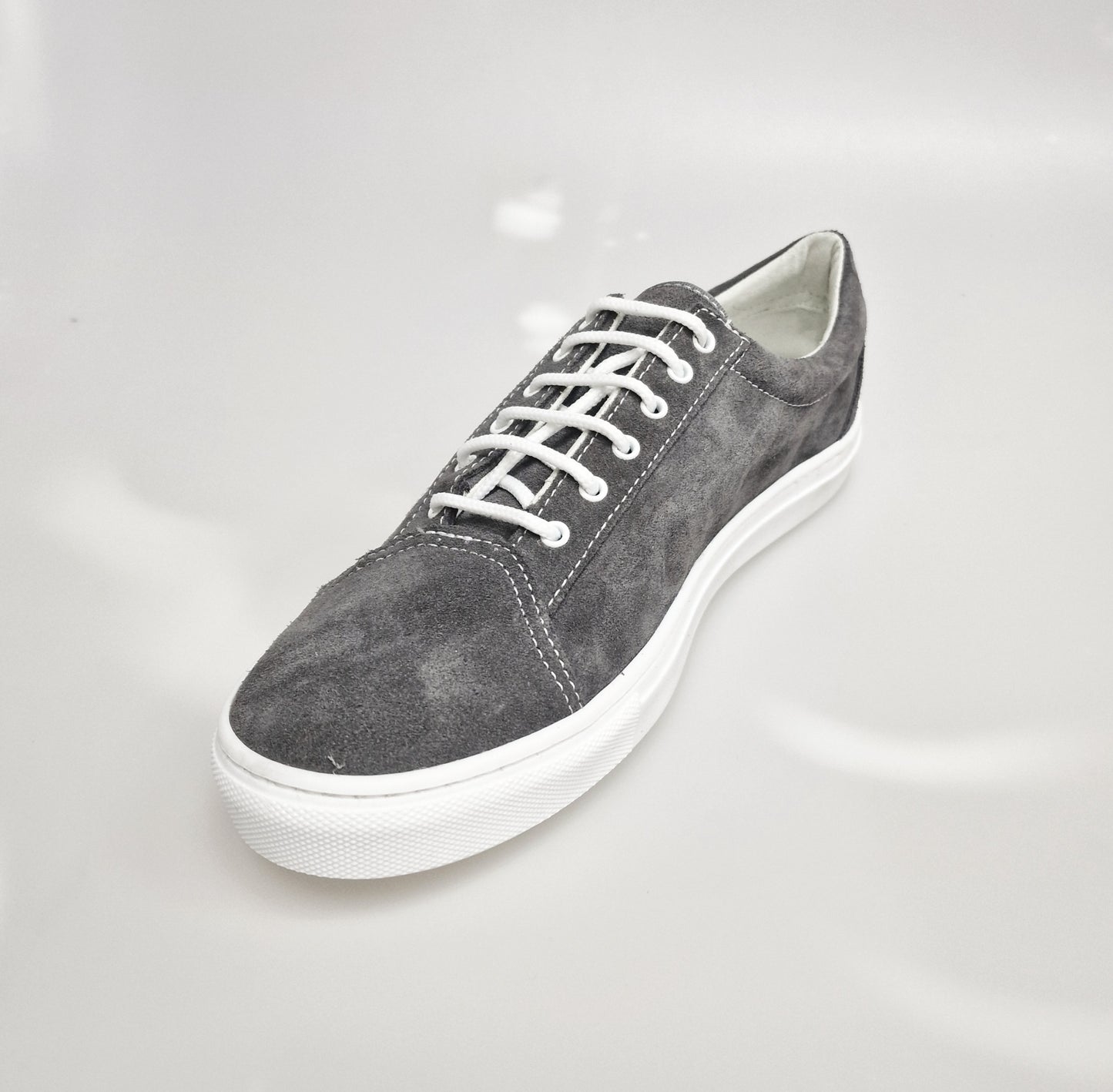 Sneaker urban in camoscio grigio Albir Ceniza con cuciture bianche e suola in resina di gomma bianca, comoda e versatile.