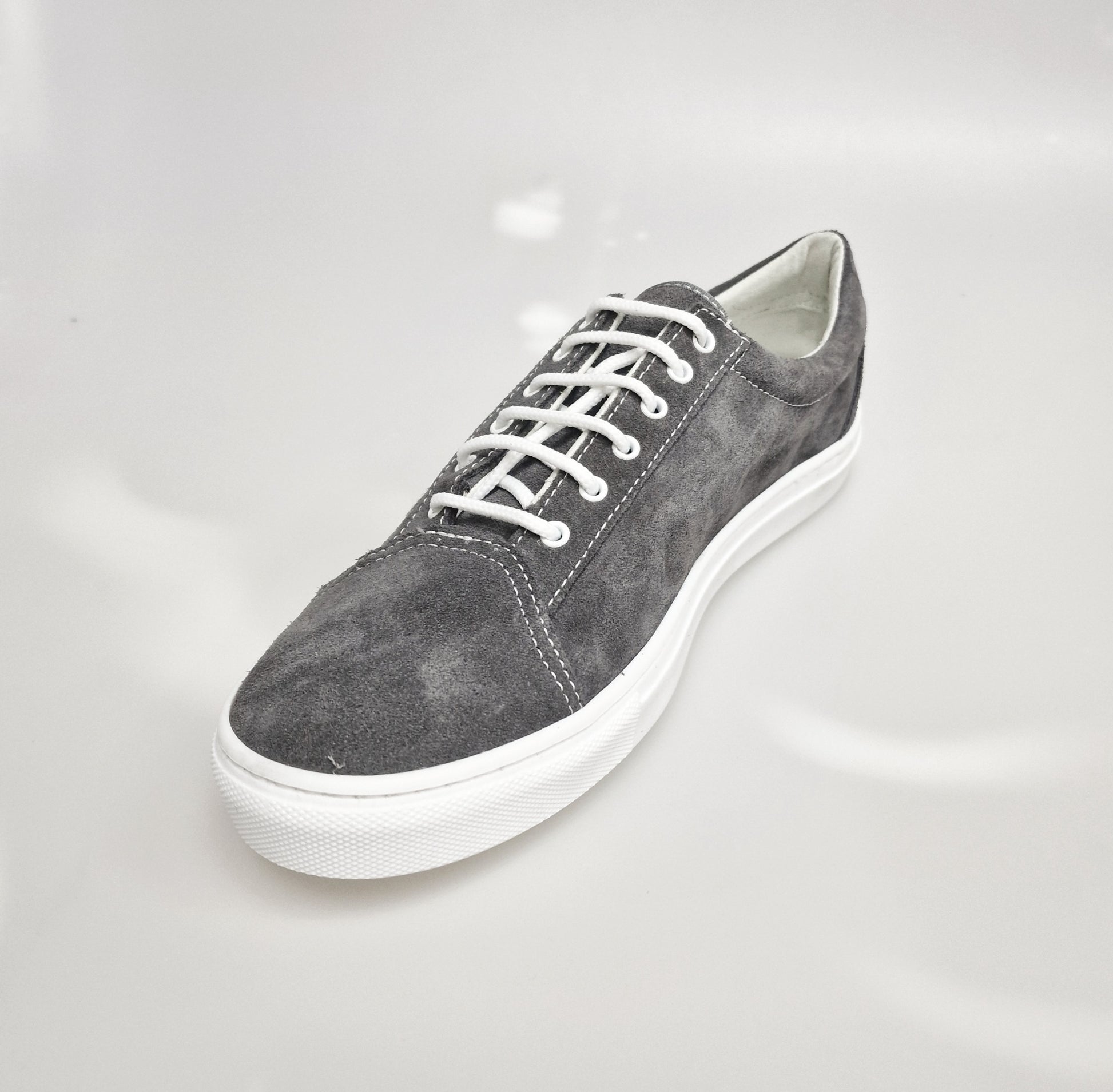 Sneaker urban in camoscio grigio Albir Ceniza con cuciture bianche e suola in resina di gomma bianca, comoda e versatile.