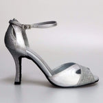Cargar imagen en la Galería, Scarpa da donna Wishdance Ely QA in pelle argento e glitter, cinturino alla caviglia e tacco rocchettino elegante.
